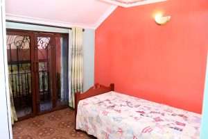 Bedroom with red accent wall in the Ruiru villa