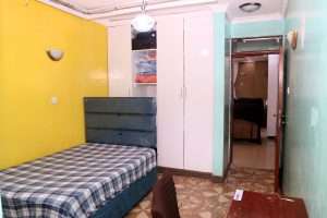 Bedroom with yellow accent wall in the Ruiru villa